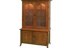 The exterior of the Arched Double Door Gun Cabinet features large shaker top molding, mullion arched upper doors with frosted glass, and arch flat panel doors on the lower cabinet.