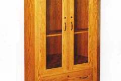 Amish made one piece corner gun cabinet with two full extension drawers in the base.  This gun cabinet was Amish custom crafted out of solid red oak with a S-2 stain finish.
