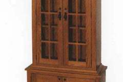 Solid oak mission two door gun cabinet with shaker mullion glass door.  Upper cabinet features our Shaker molding and lower cabinet features two lockable flush mount doors with adjustable shelf.