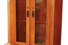 The mission corner gun cabinet is shown crafted out of solid quarter sawn white oak.  The doors and drawers are all made with semi overlay shaker craftsmanship and the upper doors feature decorative mullions.