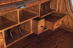 Numerous cubby holes and storage drawers are shown in the Farmer's custom Amish built roll top desk. These are all under the roll top.